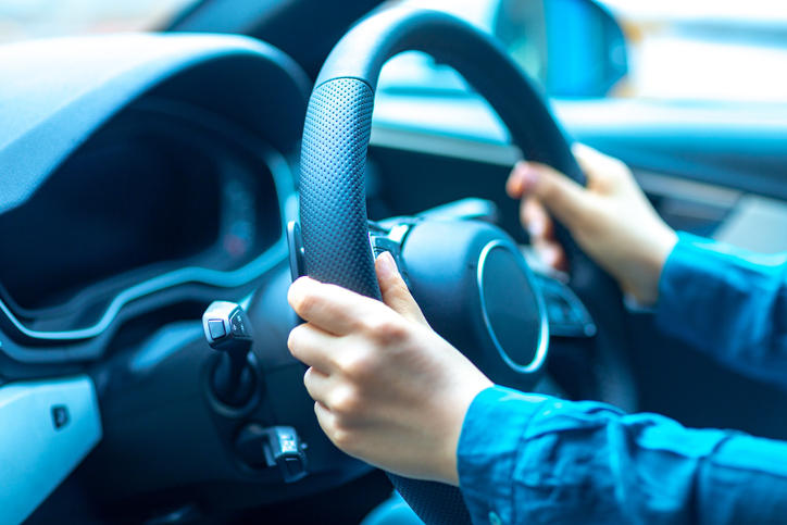 車のハンドルを持って運転している様子