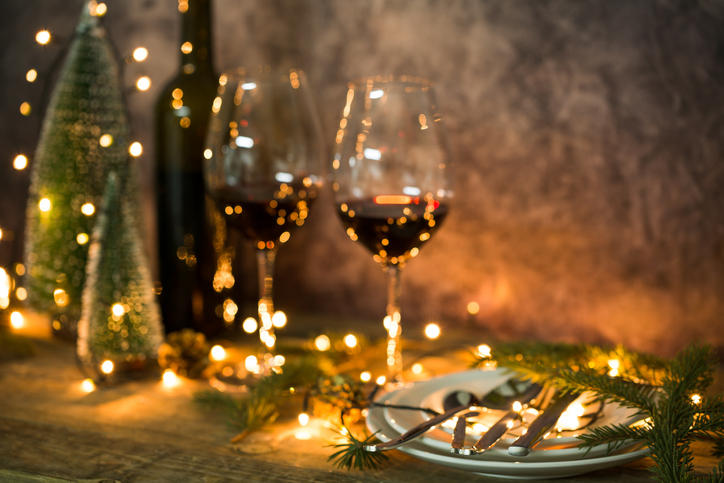 クリスマスツリーとワイングラスがテーブルに並ぶ