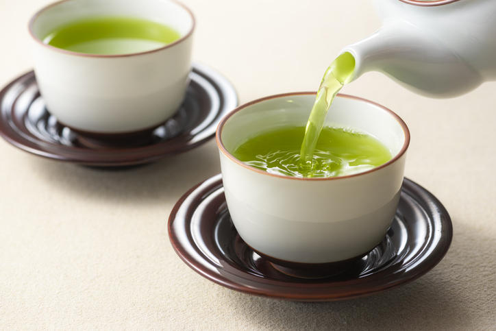 緑茶の入った茶器と今まさに緑茶が注がれている茶器