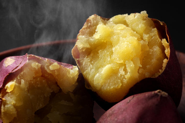 茶色い皿にのった湯気の出ているさつまいも