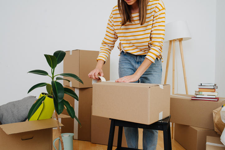荷物を段ボールに詰める女性