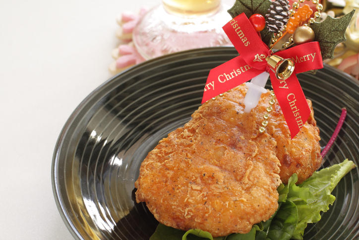黒っぽい皿に盛られたクリスマスデコレーション付きのフライドチキン