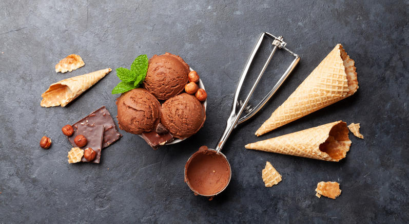 3つのワッフルコーンとお皿に盛られた3つのチョコレートアイスと銀色のアイストング