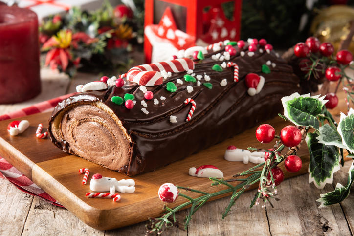 木のプレートにのったブッシュドノエルとクリスマスの飾り