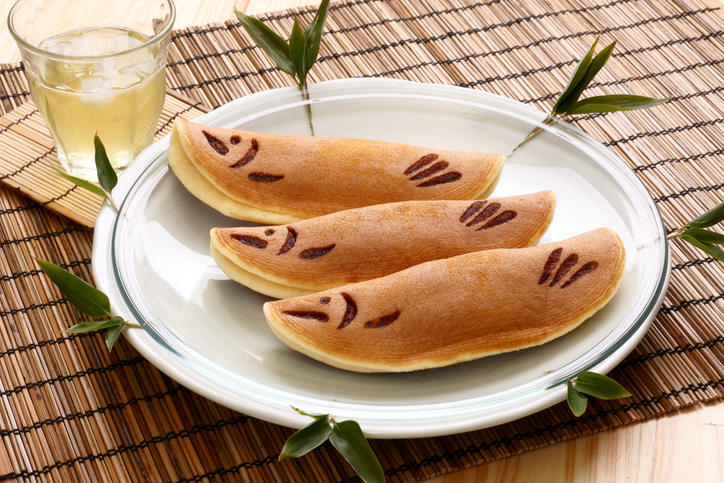 白い皿にのった鮎菓子と冷たいお茶