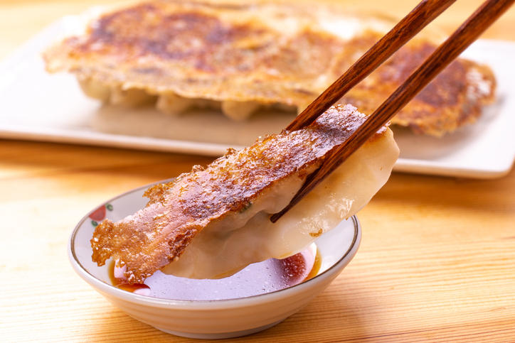 焼き餃子をたれにつけている