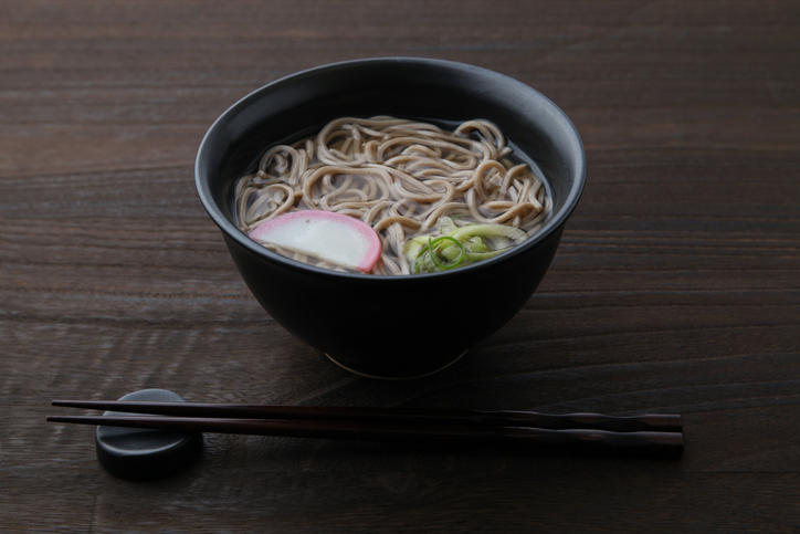 黒っぽい丼に盛られた温かいそば