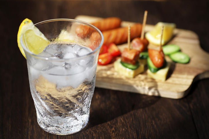 レモンを絞った焼酎と料理が並べられている