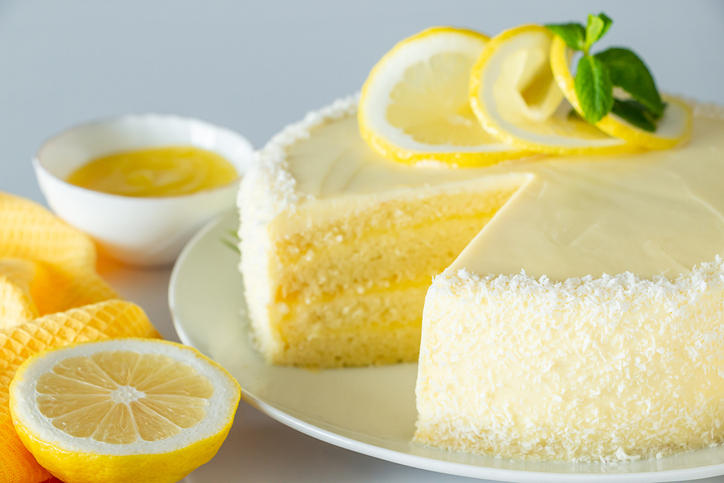 ホールのレモンケーキの横に、半分にカットされたレモンが置かれている