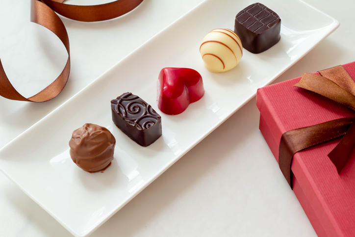 四角い白い皿に盛られた5粒のチョコレート