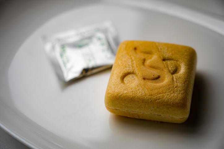 白い丸皿の上の宝の麩と銀の袋入り調味料のクローズアップ