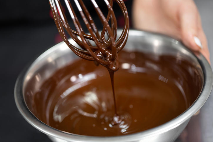 ボウルで溶かしたチョコレートをヘラで攪拌している
