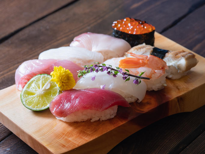 寿司下駄にのせられたマグロやイカ、いくらなどのお寿司