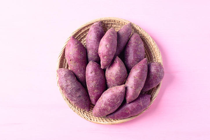 薄茶色のかごに盛られたたくさんのさつまいも