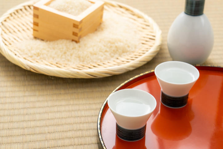 枡に入った米と猪口に注がれた日本酒が置かれている
