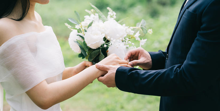 結婚式で指輪の交換をしている夫婦