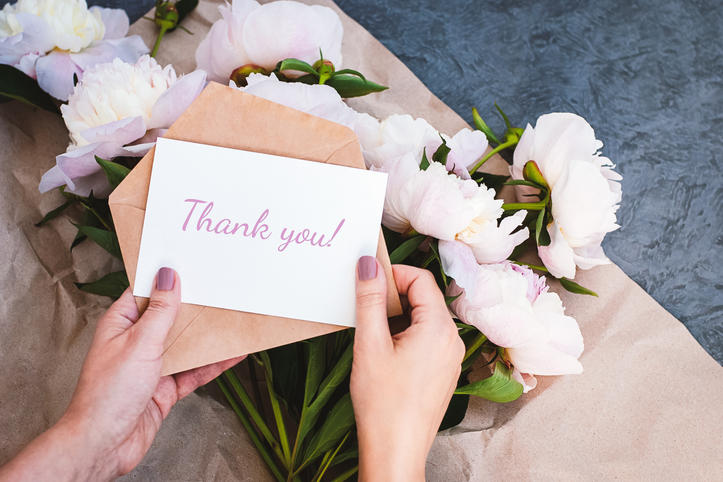 薄いピンクの牡丹の花束と「Thank You」と書かれた白色のメッセージカード