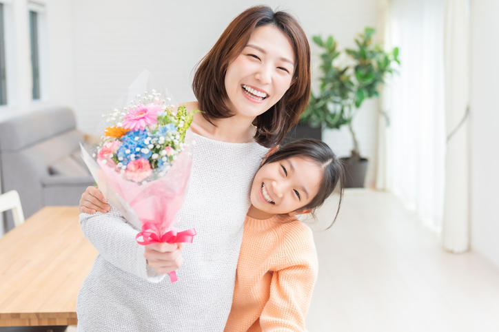 母の日に花束をもらって笑顔の母と娘