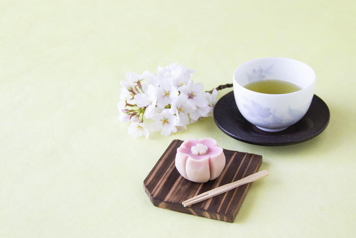 淡いグリーンの背景に置かれた日本茶と和菓子