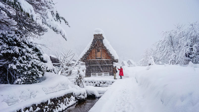 雪が降る白川郷に2人の人が訪れている