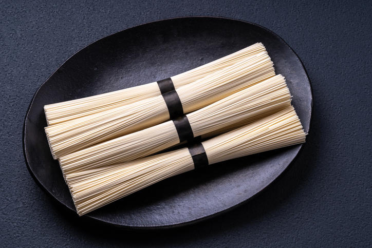 黒い器のなかに乾燥したそうめんが束ねて4つ置いてある
