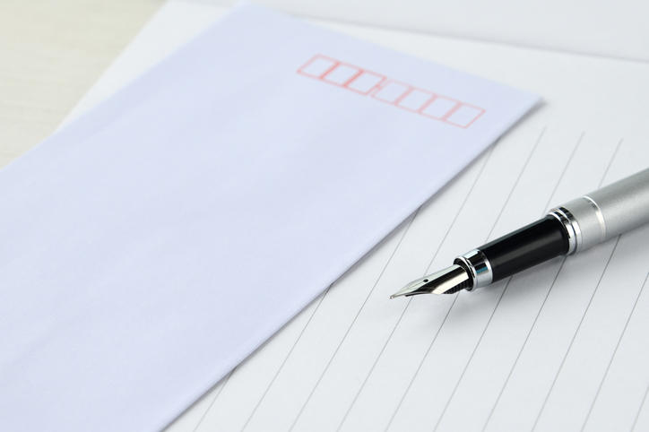 縦書きの便箋と白い封筒、万年筆が置かれている様子