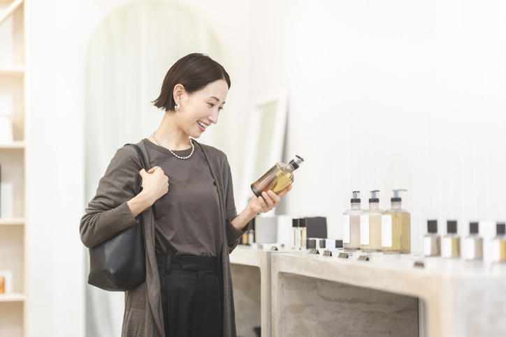 髪の短い女性が商品を手に取って選んでいる