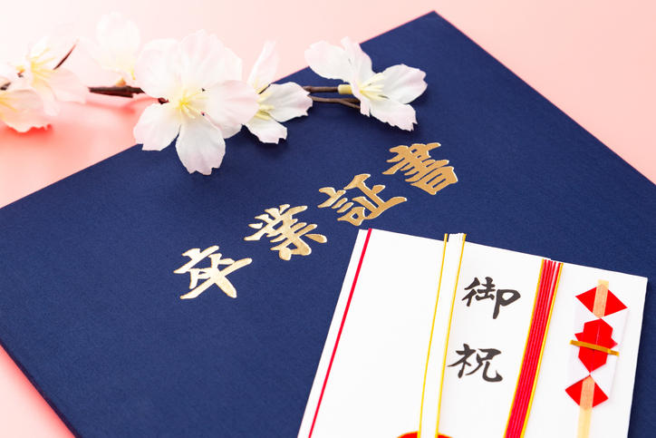 紺色の卒業証書とご祝儀袋が置かれている様子