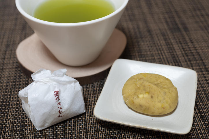 お皿にのせた栗きんとんと湯呑みに入った緑茶