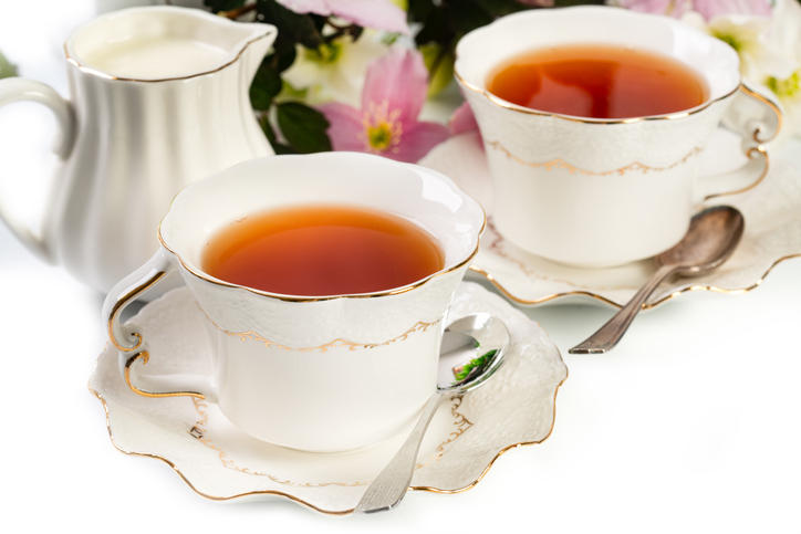 2客の紅茶が注がれてた白いティーカップとミルクピッチャーが置かれている