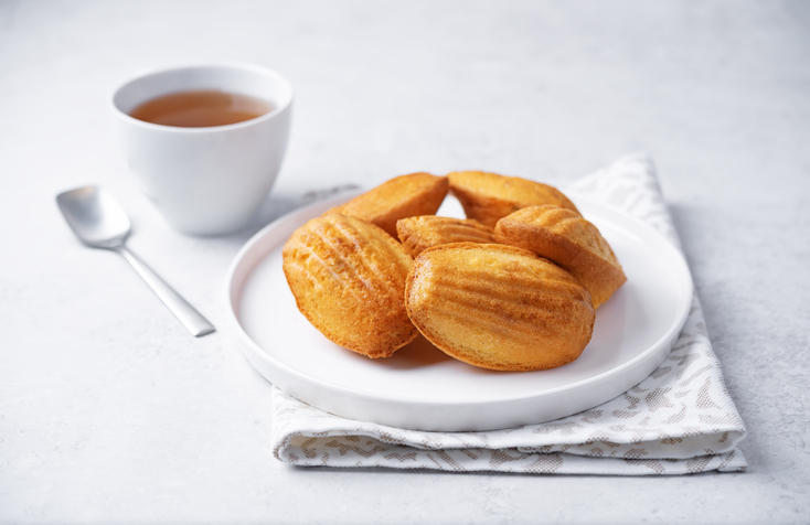 白い皿にのったマドレーヌとお茶