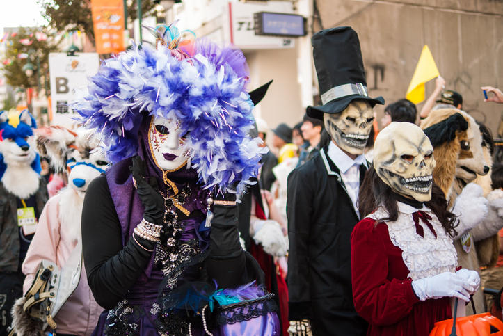 ハロウィンの仮装をした人たちがパレードで街を歩いている