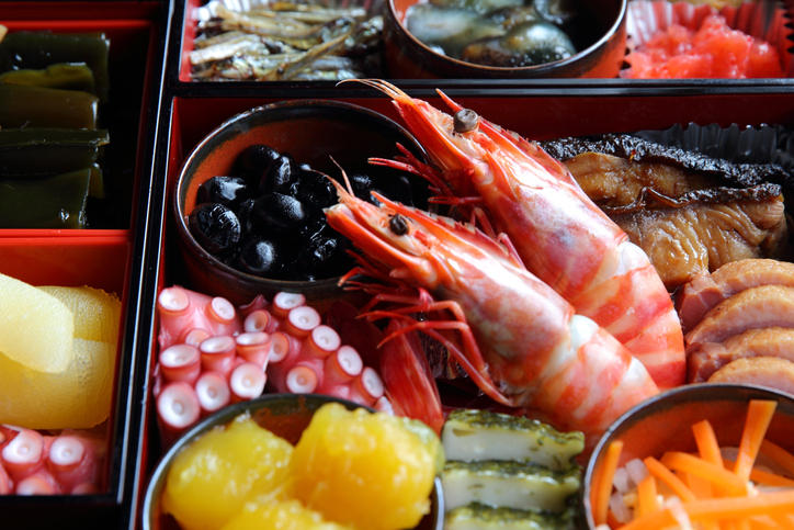 おせちのお重にえび、栗きんとん、黒豆煮などが詰められている