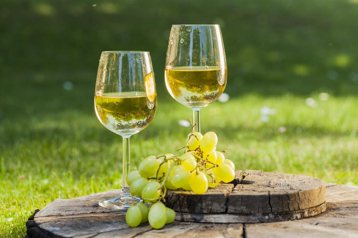 グラスに入った白ワインと白ブドウが並んでいる