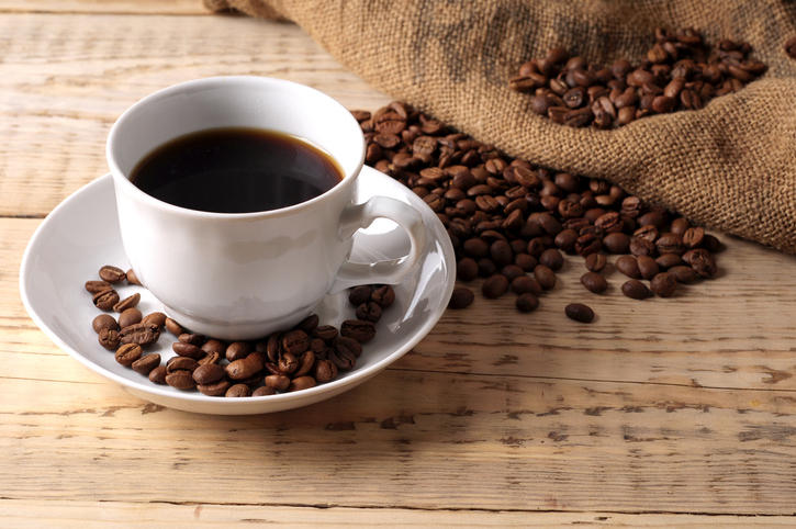 コーヒーが入ったカップとコーヒー豆が置かれている