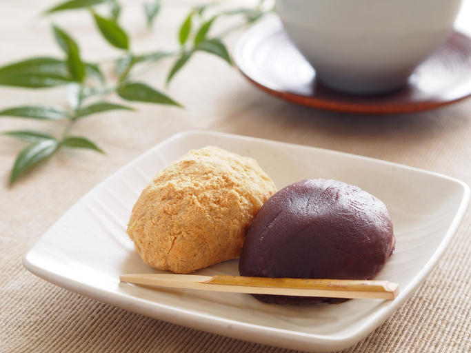 白い皿に盛られたぼたんもちときなこのおはぎ