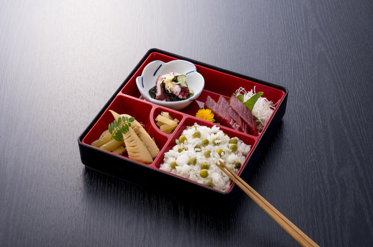 ダークブラウンの木製のテーブルに置かれた松花堂弁当