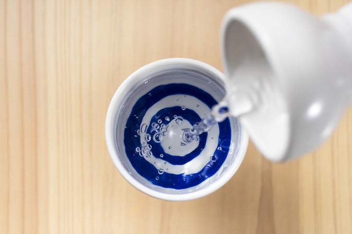 猪口に日本酒が注がれているのを真上から見下ろしている