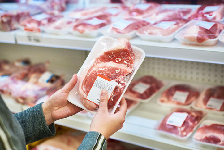 パックに入った肉を手で持ち上げている様子