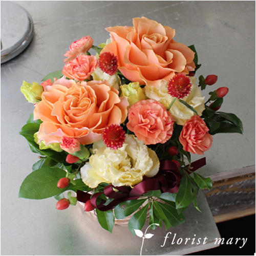 オレンジ系の花のアレンジメント。