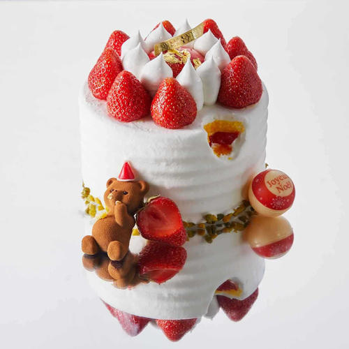 ホールサイズのいちごのショートケーキと小さなテディベアが置かれている。