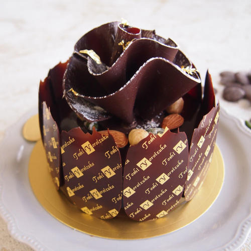 白い皿に置かれたチョコレートとピスタチオのホールケーキ