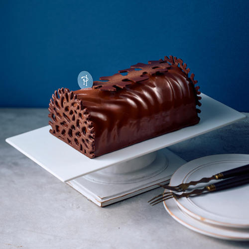 白い皿にのったピエール・エルメ・パリの「(21)ビュッシュ ルーミ＜12月24日午前11時から午後2時受け取り＞」