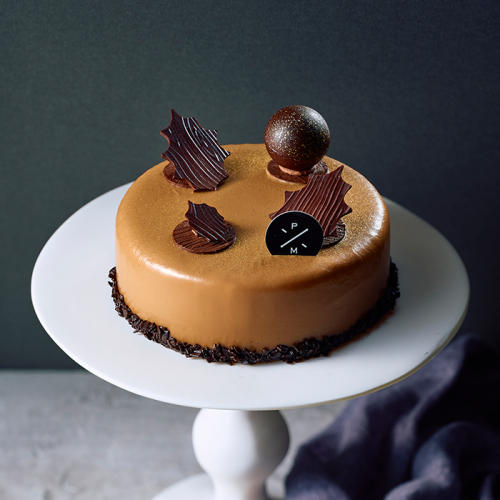 白い皿にのったピエール マルコリーニの「(22)ノエル ドゥ ピエール2025 ガトー ムース オ キャラメル＜12月24日午前11時から午後2時受け取り＞」