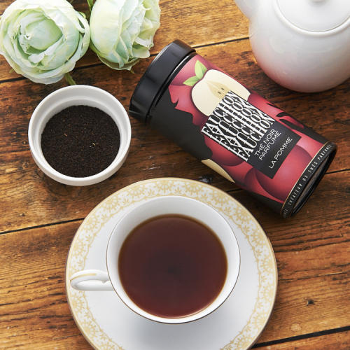 フォションのアップルの紅茶缶と紅茶が注がれた白いティーカップが置かれている