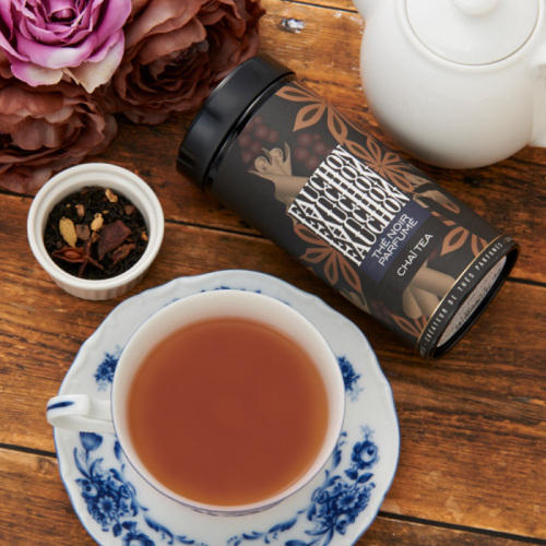 フォションのチャイの紅茶缶と紅茶が注がれた青い花柄のティーカップが置かれている