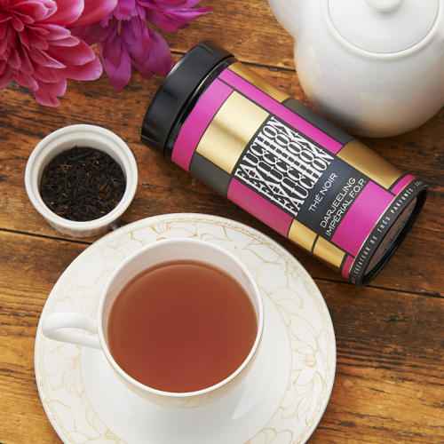 フォションダージリンのピンク缶と紅茶が注がれた白いティーカップが置かれている