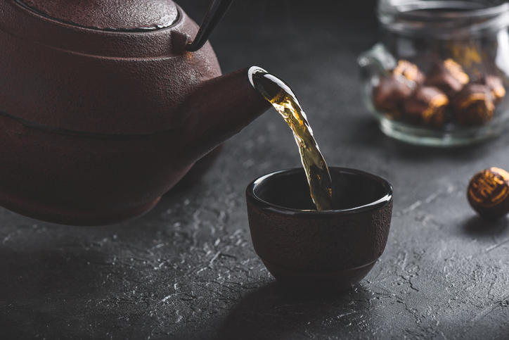黒いお茶碗に鉄瓶で紅茶が注がれている