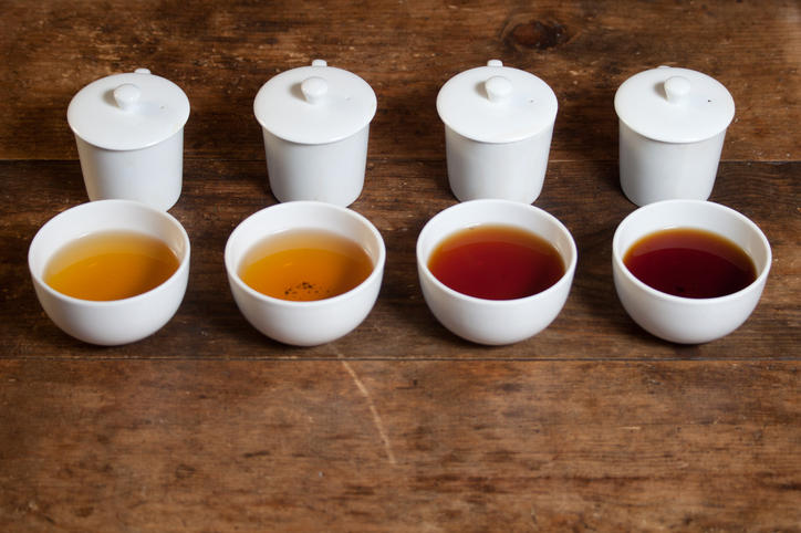 4つの白いテイスティングカップに紅茶や烏龍茶が注がれている